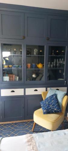 a living room with blue cabinets and a chair at spacious self-contained accommodation 135 cantebury road Herne bay CT6 5RZ in Kent