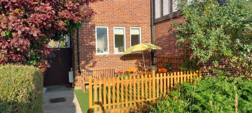 a house with a wooden fence and a yellow umbrella at spacious self-contained accommodation 135 cantebury road Herne bay CT6 5RZ in Kent
