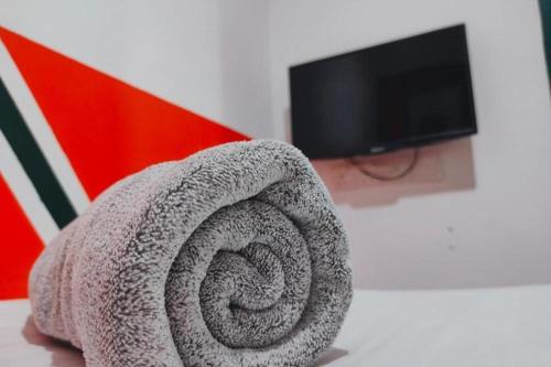 a roll of grey towel sitting on a table next to a tv at BR Parklands Hotel in Klang