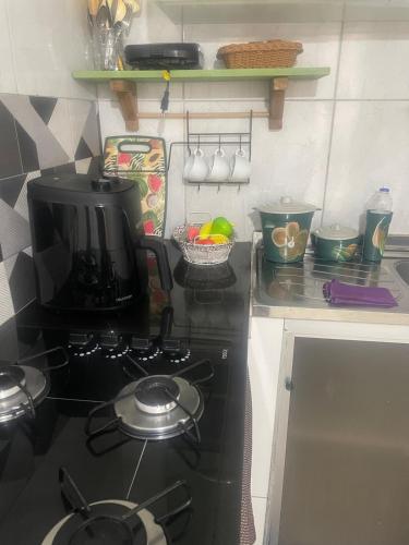 a kitchen stove with a pot on top of it at Kitnet Adorável na sedede Aracruz ES 1KM do centro individual wifi cozinha equipada in Aracruz