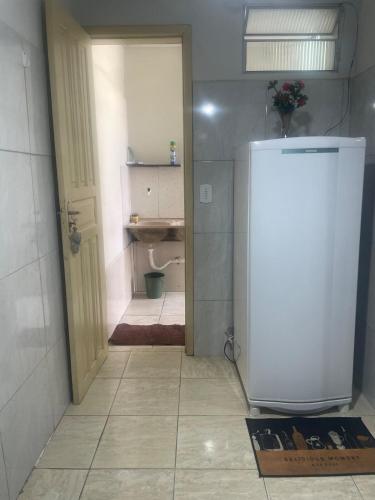 a bathroom with a white refrigerator in a room at Kitnet Adorável na sedede Aracruz ES 1KM do centro individual wifi cozinha equipada in Aracruz