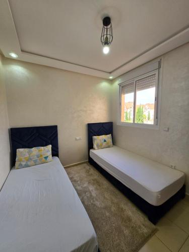 a bedroom with two beds and a window at Appartement de luxe in Ifrane