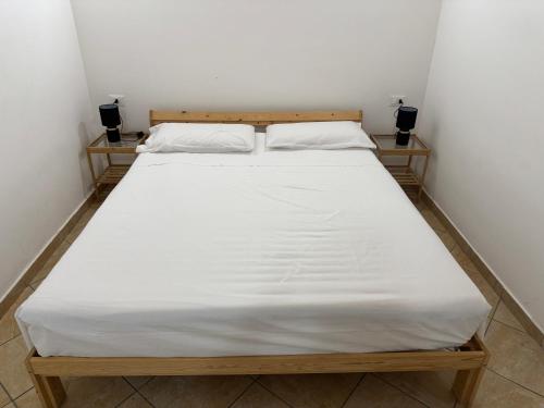 a large white bed in a small room at Perla Marina in Trappeto