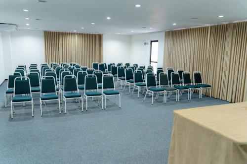 a room with a bunch of chairs and a table at Camaçari Plaza Hotel in Camaçari