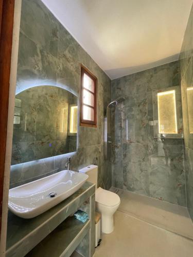 a bathroom with a sink and a toilet and a shower at Rastoni Apartments Skiathos in Troulos