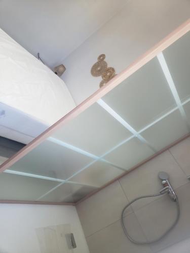 Un mono sentado en un estante encima de una ducha. en Agréable maison avec vue panoramique, en La Bourboule