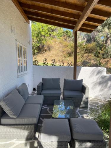 a patio with couches and a table on a patio at Rastoni Apartments Skiathos in Troulos