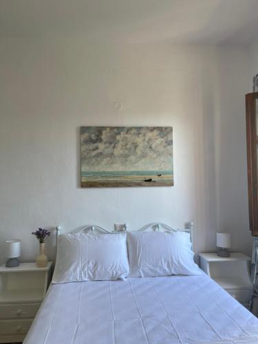 a bedroom with a bed with a painting on the wall at Rastoni Apartments Skiathos in Troulos