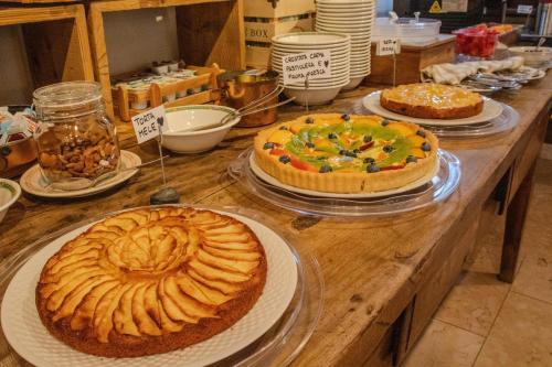 three cakes on a wooden table in a bakery at Paradise Hotel & Wellness in Saint Vincent