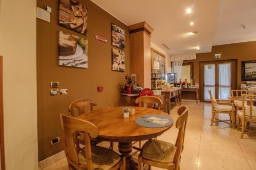 a dining room with a wooden table and chairs at Paradise Hotel & Wellness in Saint Vincent