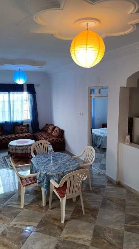 a living room with a table and chairs and a couch at résidence TASNIM in Say