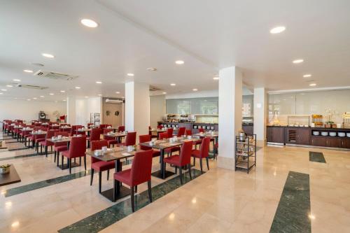 a dining room with tables and red chairs at Eurostars Plaza Acueducto in Segovia