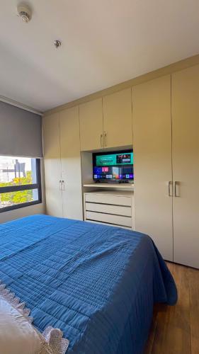 a bedroom with a blue bed and a flat screen tv at Family apartment in Carmelitas in Asuncion