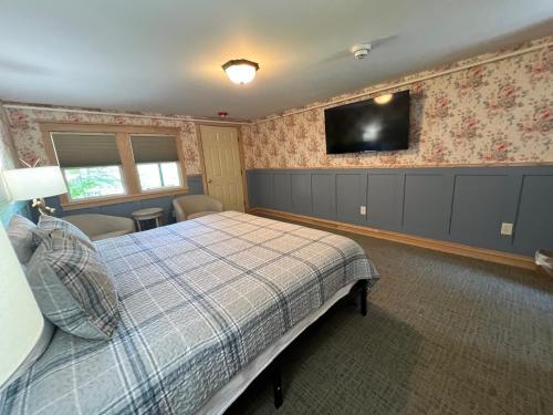 a bedroom with a bed and a tv on the wall at Stonehurst Manor Breakfast & Dinner Included in North Conway
