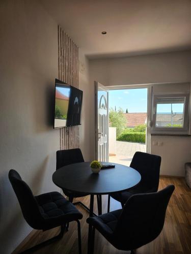 a living room with a table and chairs and a television at Apartment Olive in Maslenica
