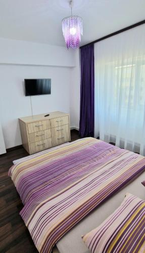 a bedroom with a large bed and a chandelier at Apartament Niki in Mangalia
