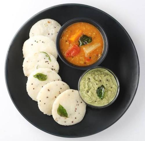a plate of food with dumplings and a bowl of dip at Hotel Prisha Recidency in Wardha