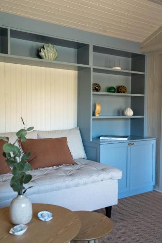 a room with a bed and a table and shelves at Skårungen - Hotel, Cabins and Camping in Kabelvåg