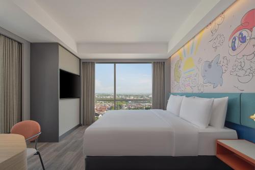 a bedroom with a large bed and a large window at Aloft Surabaya Pakuwon City in Surabaya