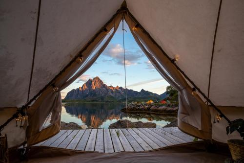 a tent with a view of a mountain and water at Skårungen - Hotel, Cabins and Camping in Kabelvåg
