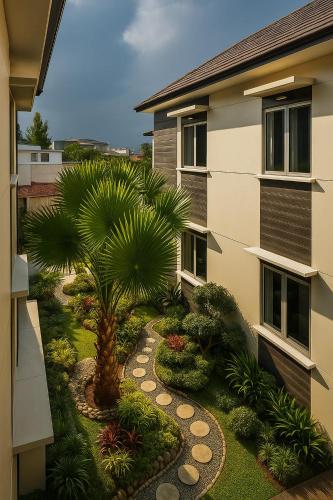 a palm tree in a yard next to a building at Cipto Apartment in Bandung