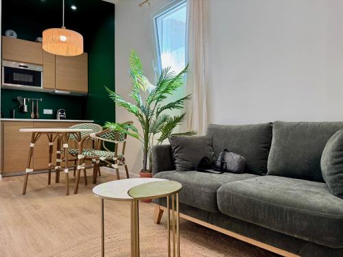 una sala de estar con un sofá y una mesa en La Suite Balinaise, en Quimper