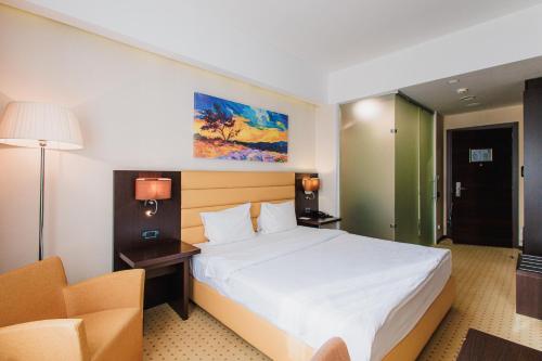 a hotel room with a bed and a chair at Comfort Hotel Astana in Astana