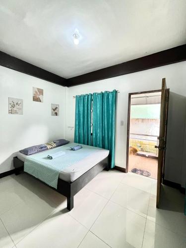 a bedroom with a bed and a large window at Longay Guesthouse in General Luna