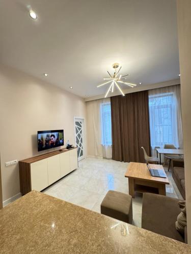 ein Wohnzimmer mit Sofa und Fernseher in der Unterkunft Elit Hauses in Yerevan