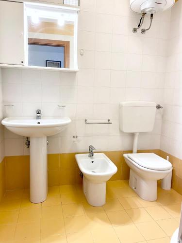 a bathroom with a sink and a toilet at Condominio Cam 78 in Lignano Sabbiadoro