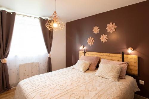 a bedroom with a bed with flowers on the wall at Gîte Chabrignac, jacuzzi et sauna privatif, piscine chauffée partagée, Wifi, salle de jeux in Beynat