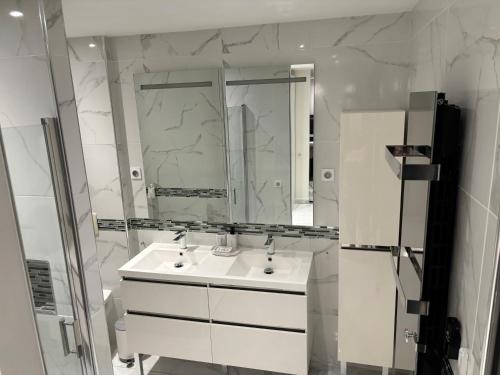 une salle de bain blanche avec un lavabo et un miroir dans l'établissement Villa luxueuse et Moderne avec piscine !, à Béziers