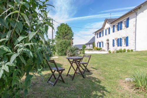 a table and chairs in a yard next to a building at Gîte Chabrignac, jacuzzi et sauna privatif, piscine chauffée partagée, Wifi, salle de jeux in Beynat