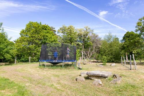 a couple of people standing on a trampoline at Gîte Chabrignac, jacuzzi et sauna privatif, piscine chauffée partagée, Wifi, salle de jeux in Beynat