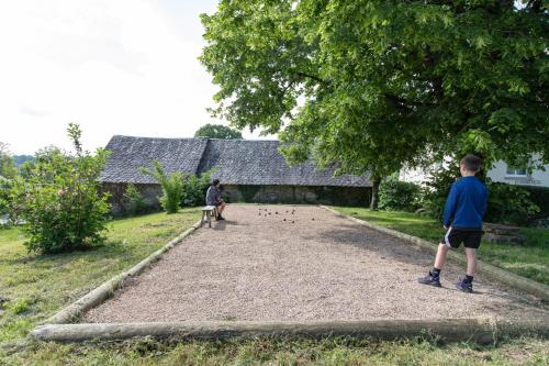 two children playing a game of dominoes in a yard at Gîte Chabrignac, jacuzzi et sauna privatif, piscine chauffée partagée, Wifi, salle de jeux in Beynat