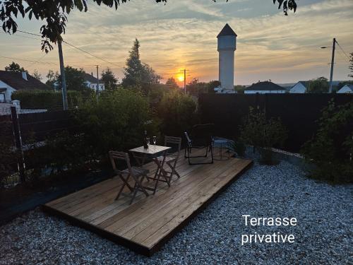 a wooden deck with chairs and a table and a lighthouse at Chambre récente chez particuliers in Francueil