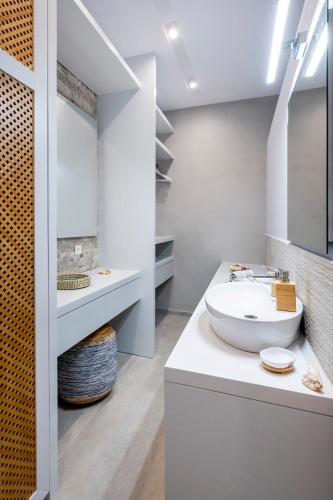a white bathroom with a sink and a mirror at Luxury studio Thomas & Irini in Kos Town