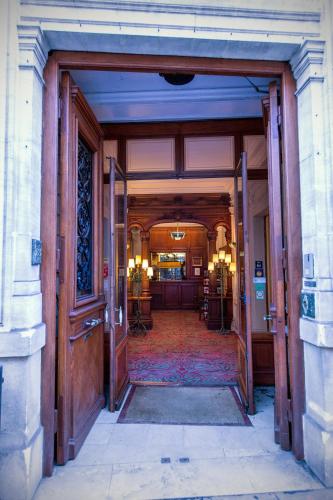 un accès à un bâtiment avec une porte ouverte dans l'établissement Hôtel Langlois, à Paris