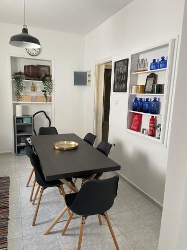 a dining room with a black table and chairs at The White House - Aianteio in Aiándion
