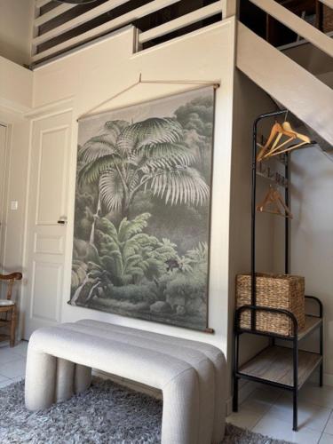a bench in a room with a painting on the wall at La Maison des Cordiers in Dinan