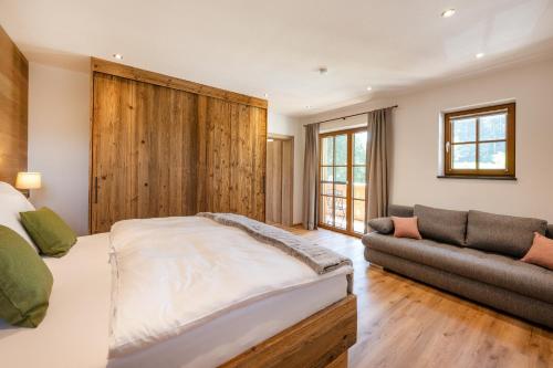 une chambre avec un grand lit et un canapé dans l'établissement Obereggut, à Hof bei Salzburg