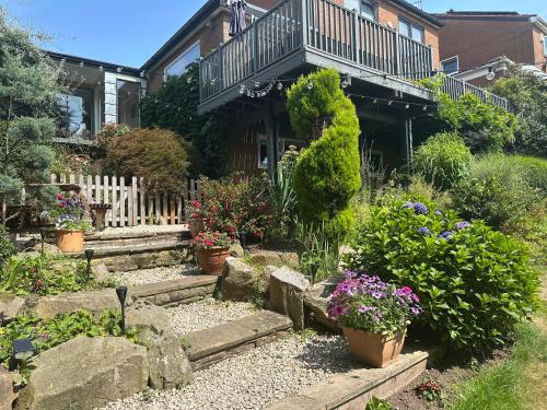 a garden in front of a house with potted plants at The Garden Apartment, Near Airport & City in Manchester