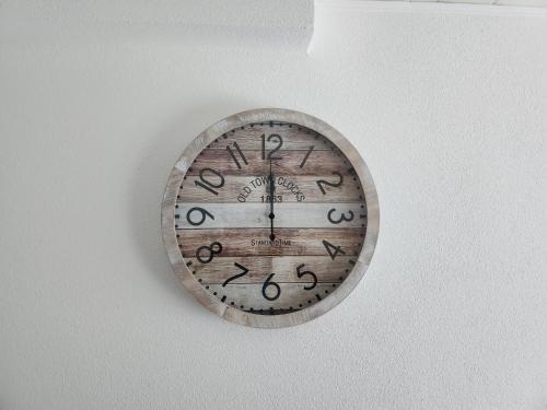 a wooden clock hanging on a wall at White Sand Haven Guest House in Ebhausen