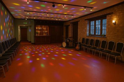 an empty room with chairs and lights on the ceiling at The Swan Hotel Oxford in Eynsham