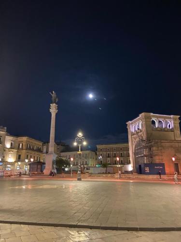 a city square at night with a statue and a moon at LECCE MON AMOUR B&B in Lecce