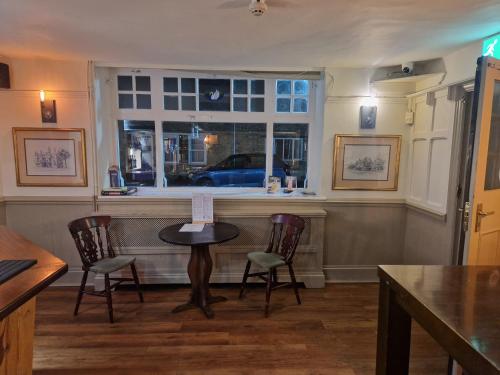 a bar with a table and chairs and a window at The Swan Hotel Oxford in Eynsham