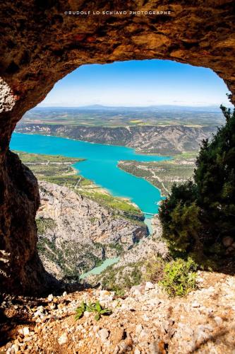 a view from the cave of a mountain overlooking a lake at Vous viendrez vivre ici 2 pièces lavandes garage à moto in Riez