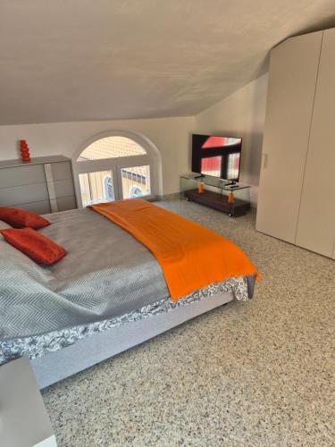 a bedroom with a bed with an orange blanket at Casa ARMANDA 2 in Rivalto