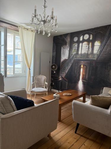 sala de estar con lámpara de araña y sala de estar con mesa en L'ideal, en Vannes