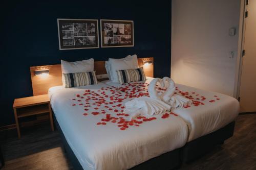 a bedroom with a bed covered in red rose petals at Landgoed Mennorode in Elspeet